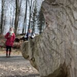 Im Vordergrund das aus Holz geschnitzte Wildschwein. Im Hintergrund zwei Frauen im Gespräch
