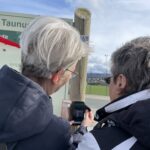Zwei Frauen schauen sich die Infotafel an
