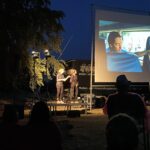 Zwei Dolmetscherinnen stehen neben der Kinoleinwand und übersetzten den Film in Gebärdensprache.