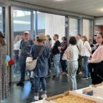 Zuschauer im Eingangsbereich vor dem Kuchenbuffet