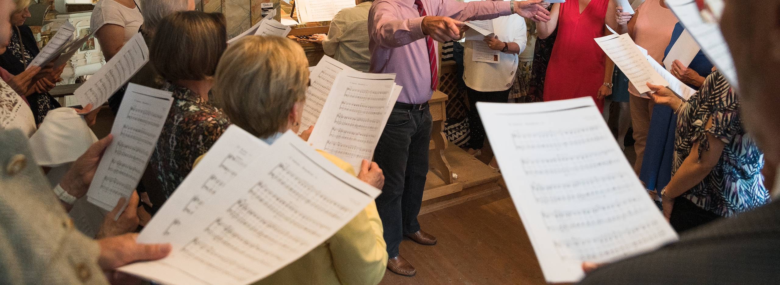 Chorprobe mit Dirigent und Noten